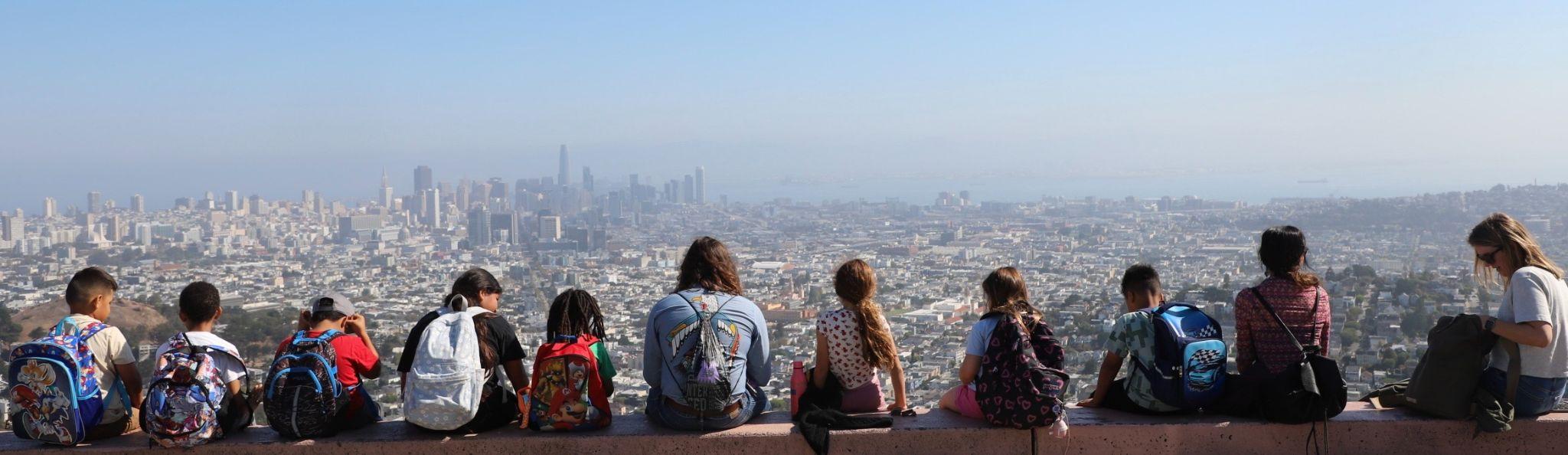 Children seen from behind at Twin Peaks, looking out over the San Francisco skyline and bay