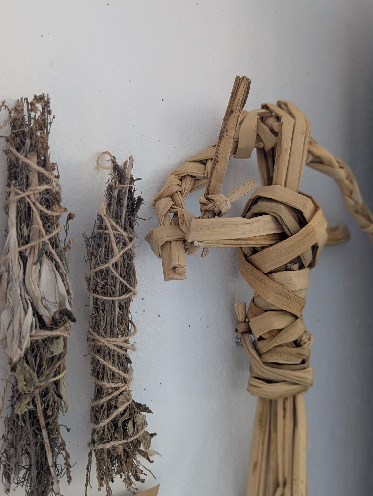 A bundle of tule reeds and natural materials bound together — raw tule prepared for weaving