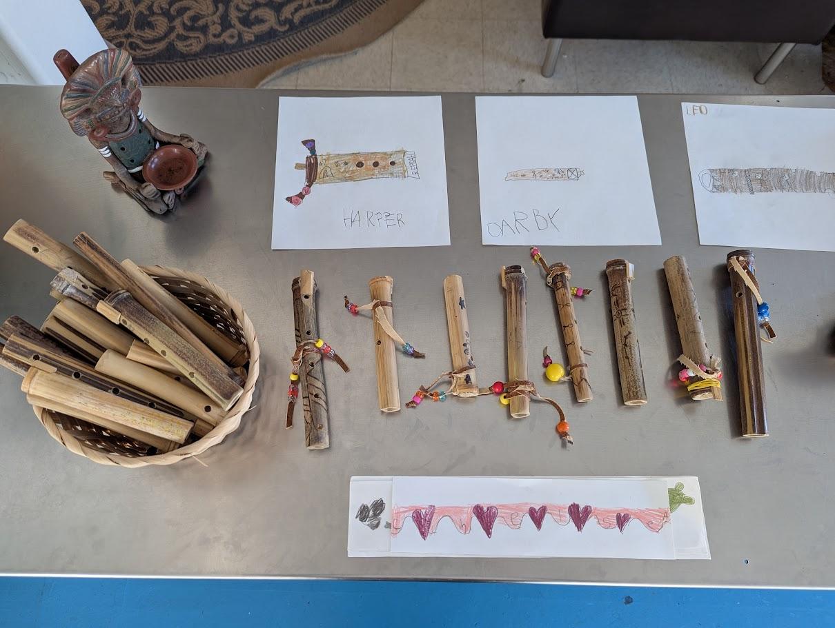 Research materials spread on a table — books, printed cards, and objects about the Ohlone people