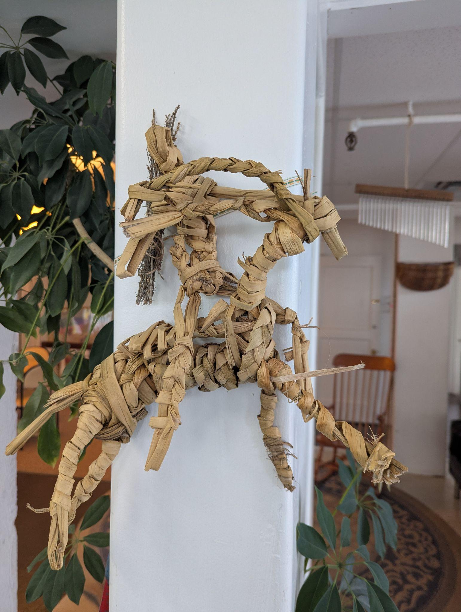 A three-dimensional tule structure hanging or displayed — a more complex assembled form made from dried reeds